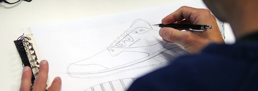 homme dessinant une chaussure au crayon à papier