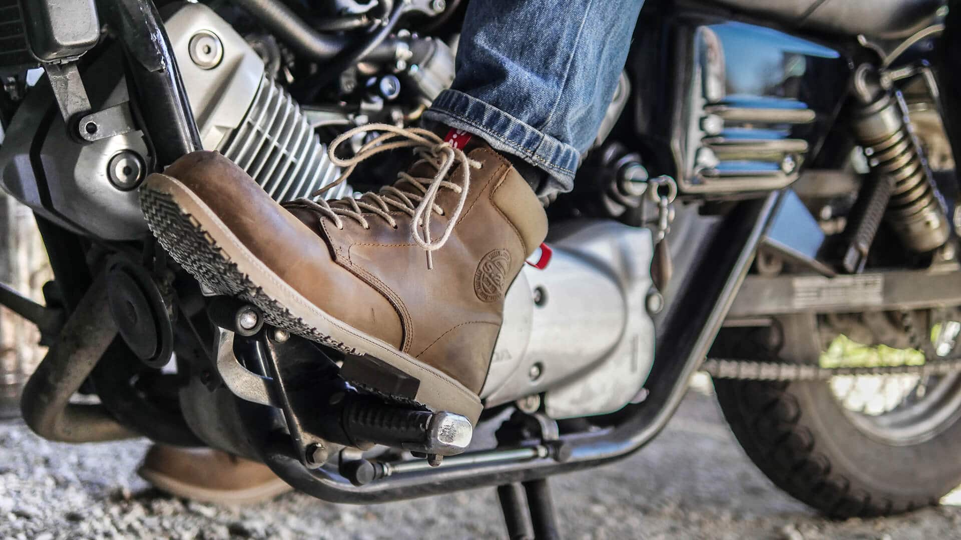 chaussure marron en cuir d'une personne sur une moto