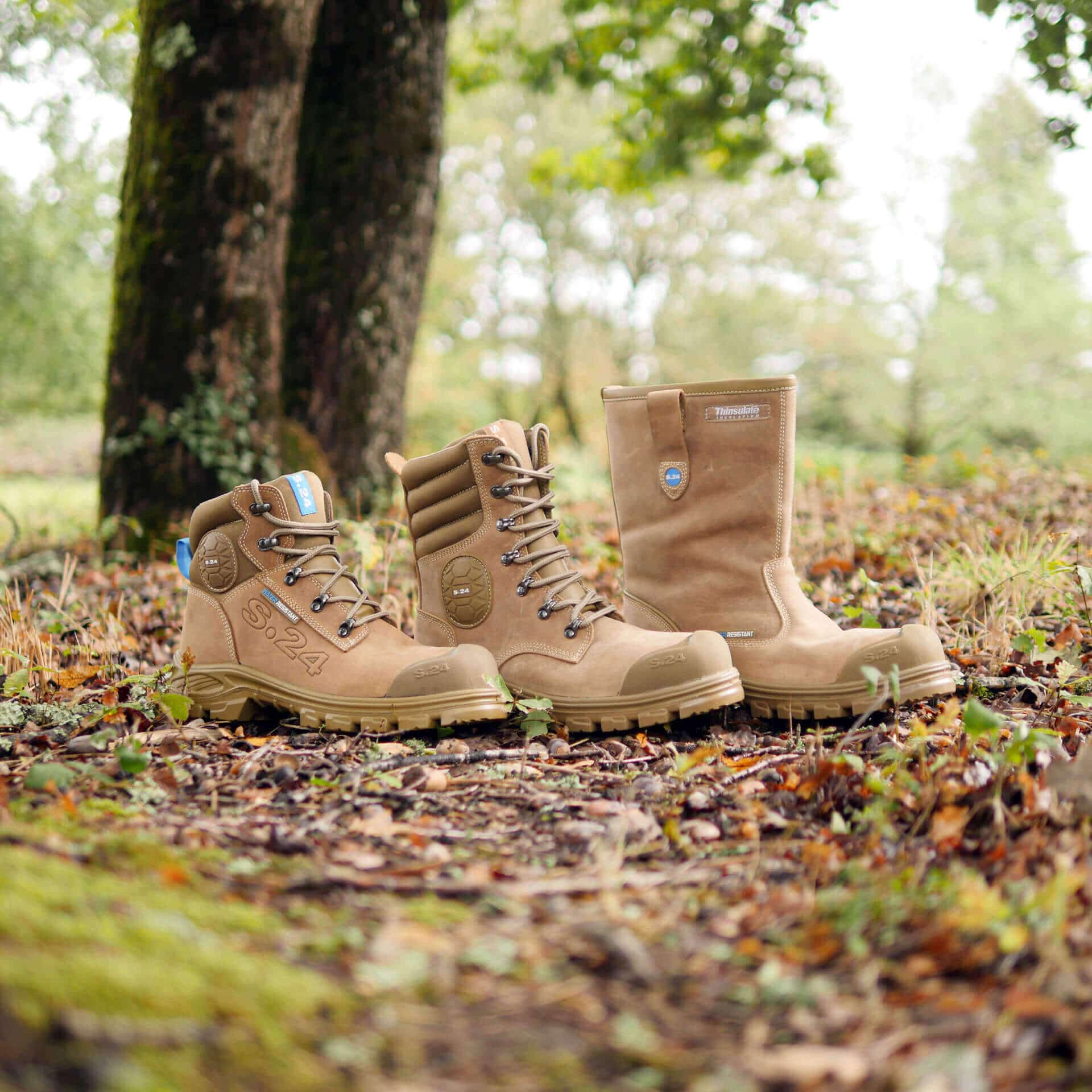 deux chaussures de sécurité et une botte de sécurité dans la forêt sur des feuilles marron