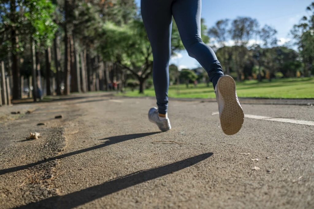 jambes d'une femme un train de courir sur une route dans un parc
