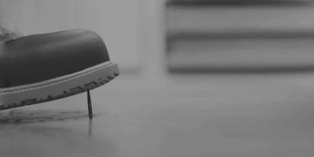 avant d'une chaussure qui marche sur un clou