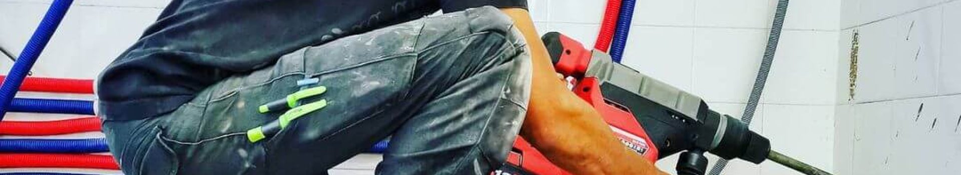 Chaussure de sécurité plombier – XPER TP S3 homme à genoux tenant une grosse perceuse