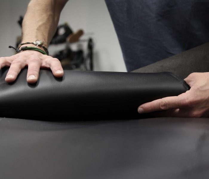 homme qui enroule du cuir noir