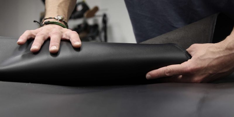 homme qui enroule du cuir noir