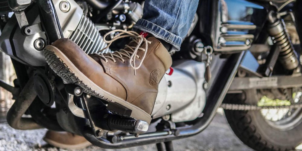 chaussure marron en cuir d'une personne sur une moto