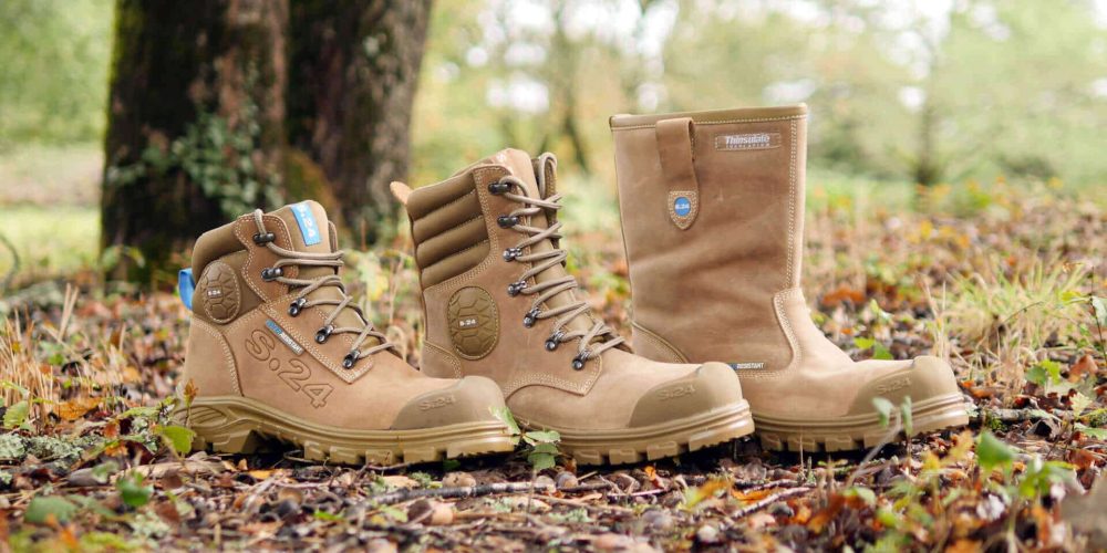 deux chaussures de sécurité et une botte de sécurité dans la forêt sur des feuilles marron