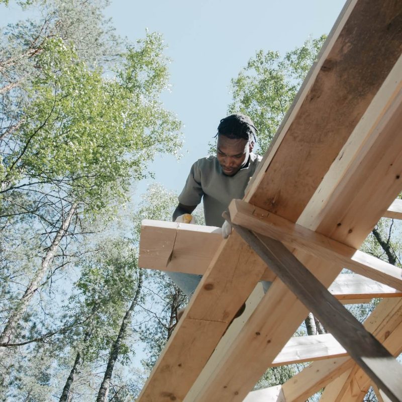 charpentier en train de couper du bois en hauteur
