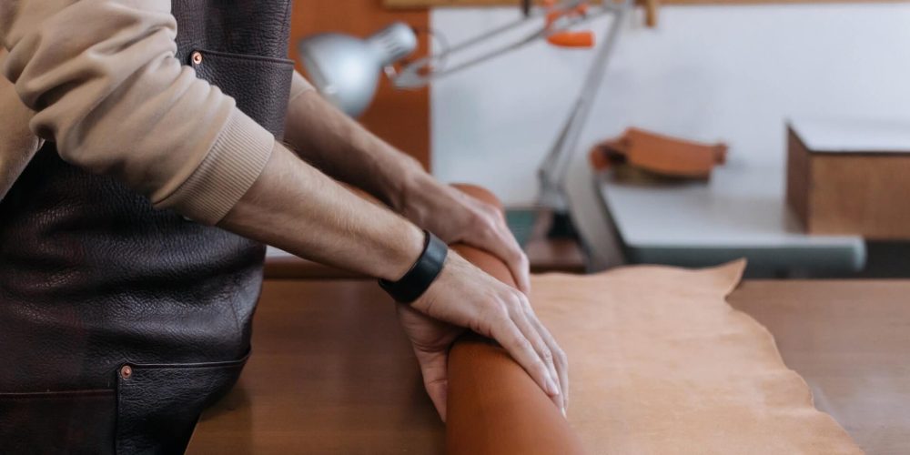homme en train de faire un rouleau de cuir