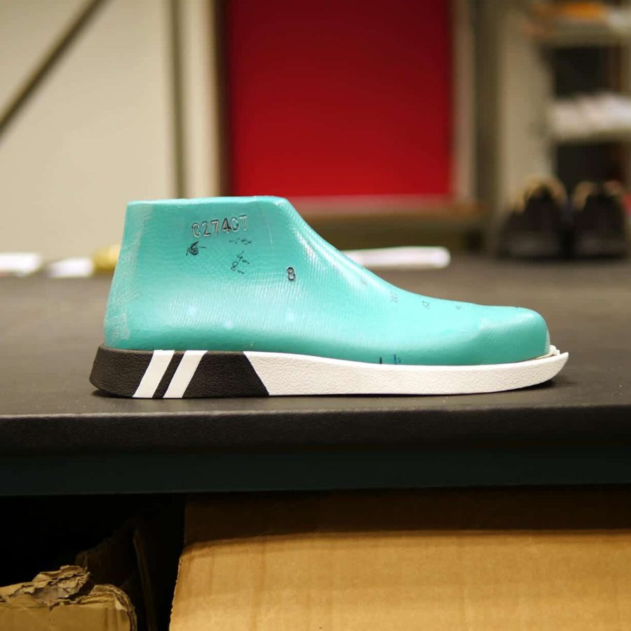 forme de pied en plastique vert posée sur une semelle blanche et noire