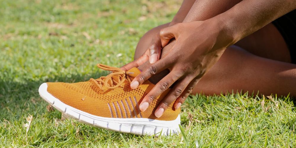 personne qui se tient la cheville