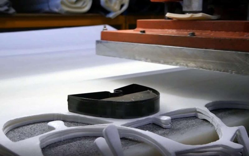 découpe emporte piece chaussure presse avec un emporte pièce qui coupent de la matière textile blanche