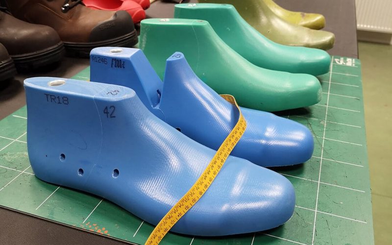 formes de pieds en plastique de couleur bleu et verte, posées sur un plan de travail