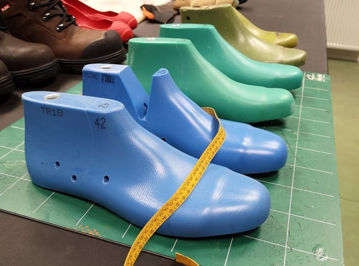 formes de pieds en plastique de couleur bleu et verte, posées sur un plan de travail
