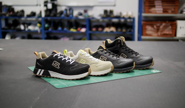 quatre chaussures alignées sur une table noire