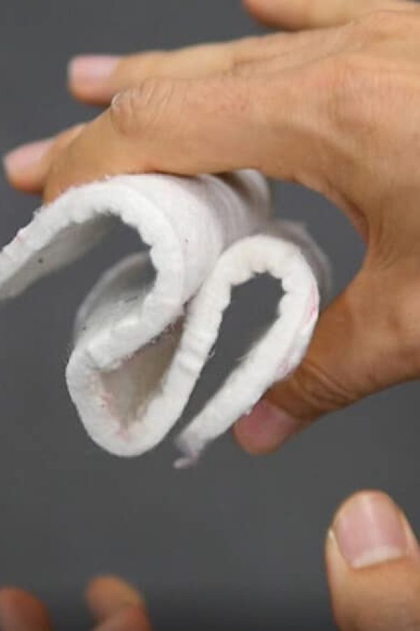 plaque d'une matière filandreuse plié entre des doigts