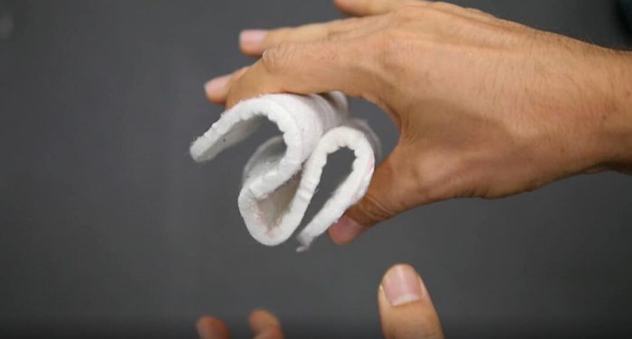 plaque d'une matière filandreuse plié entre des doigts