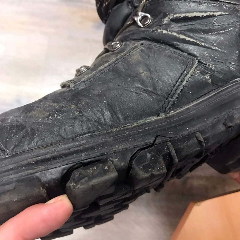 chaussure de sécurité noire en cuir avec une craquelure sur la semelle