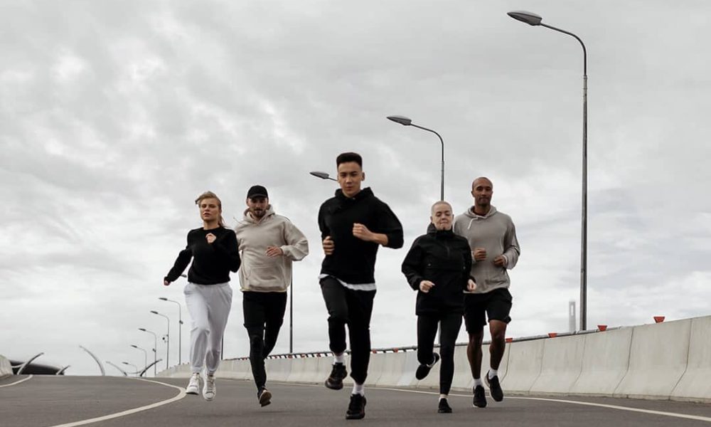groupe d'hommes et de femmes en train de courir sur une route