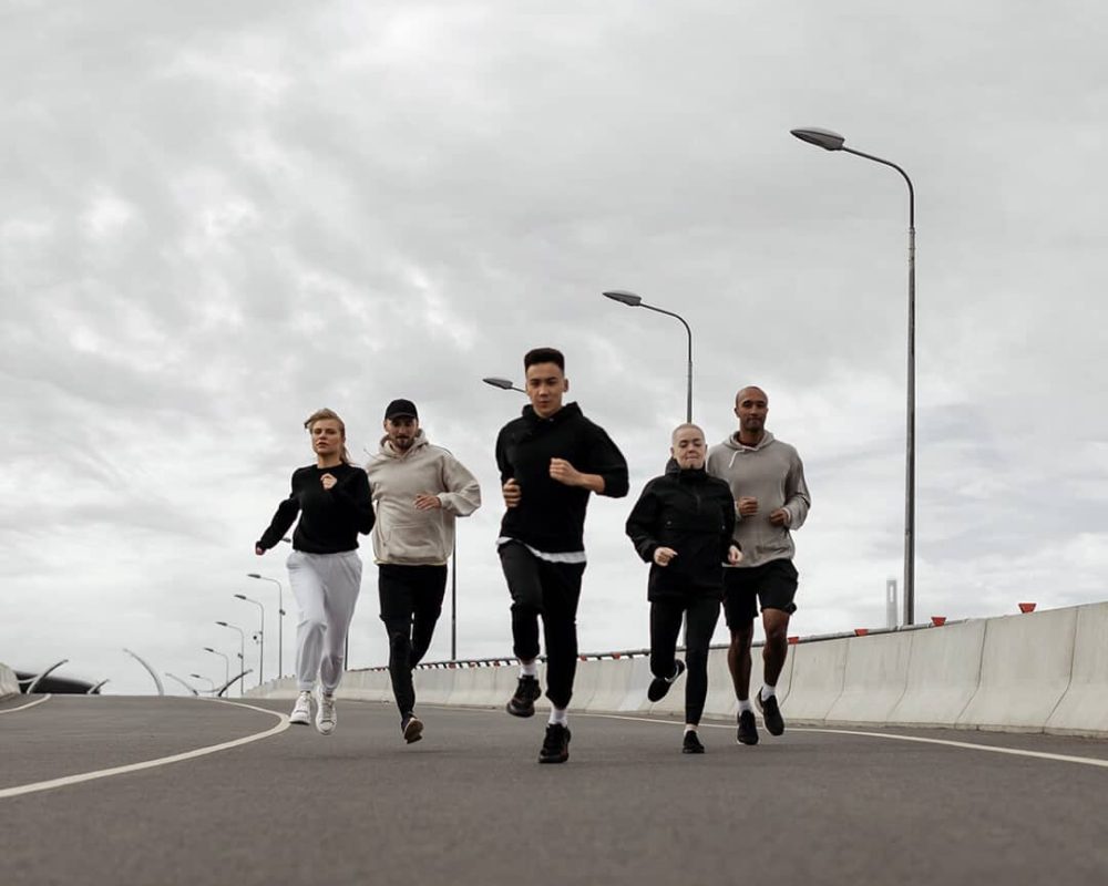 groupe d'hommes et de femmes en train de courir sur une route
