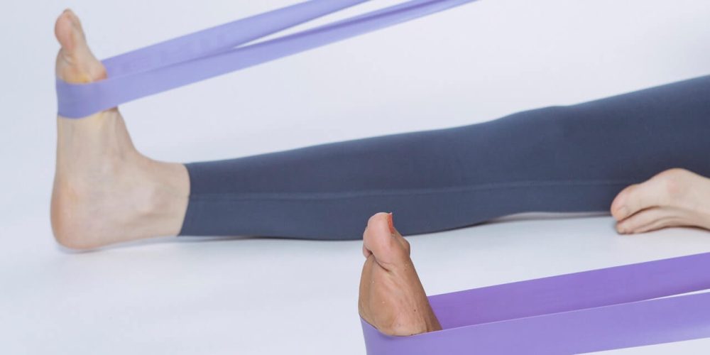 pieds étirés par un élastique violet